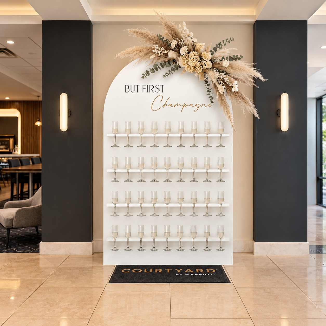 Neutral champagne wall decorated with dried florals for a graduation celebration