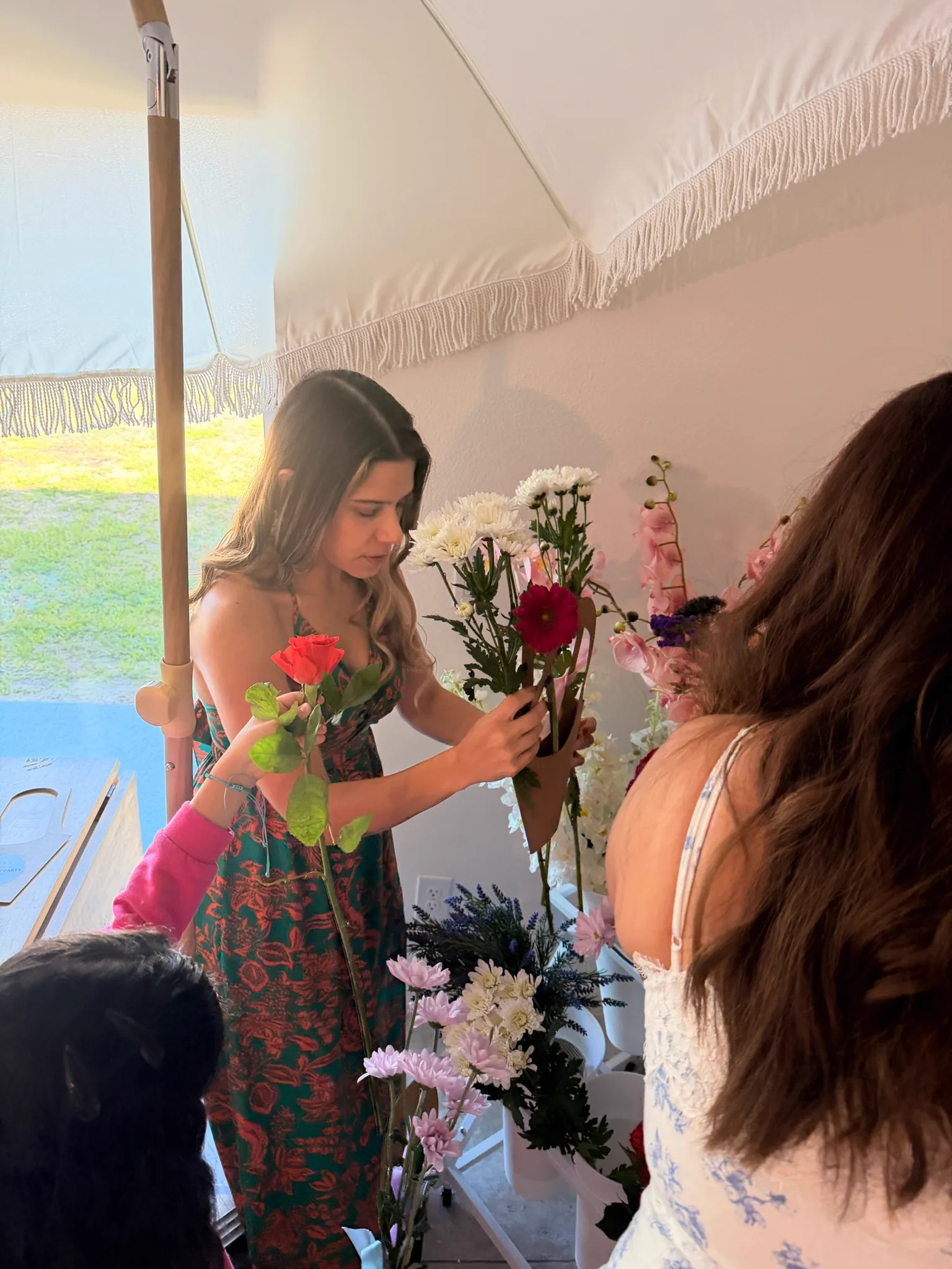 Guests arranging fresh flowers at a styled flower bar