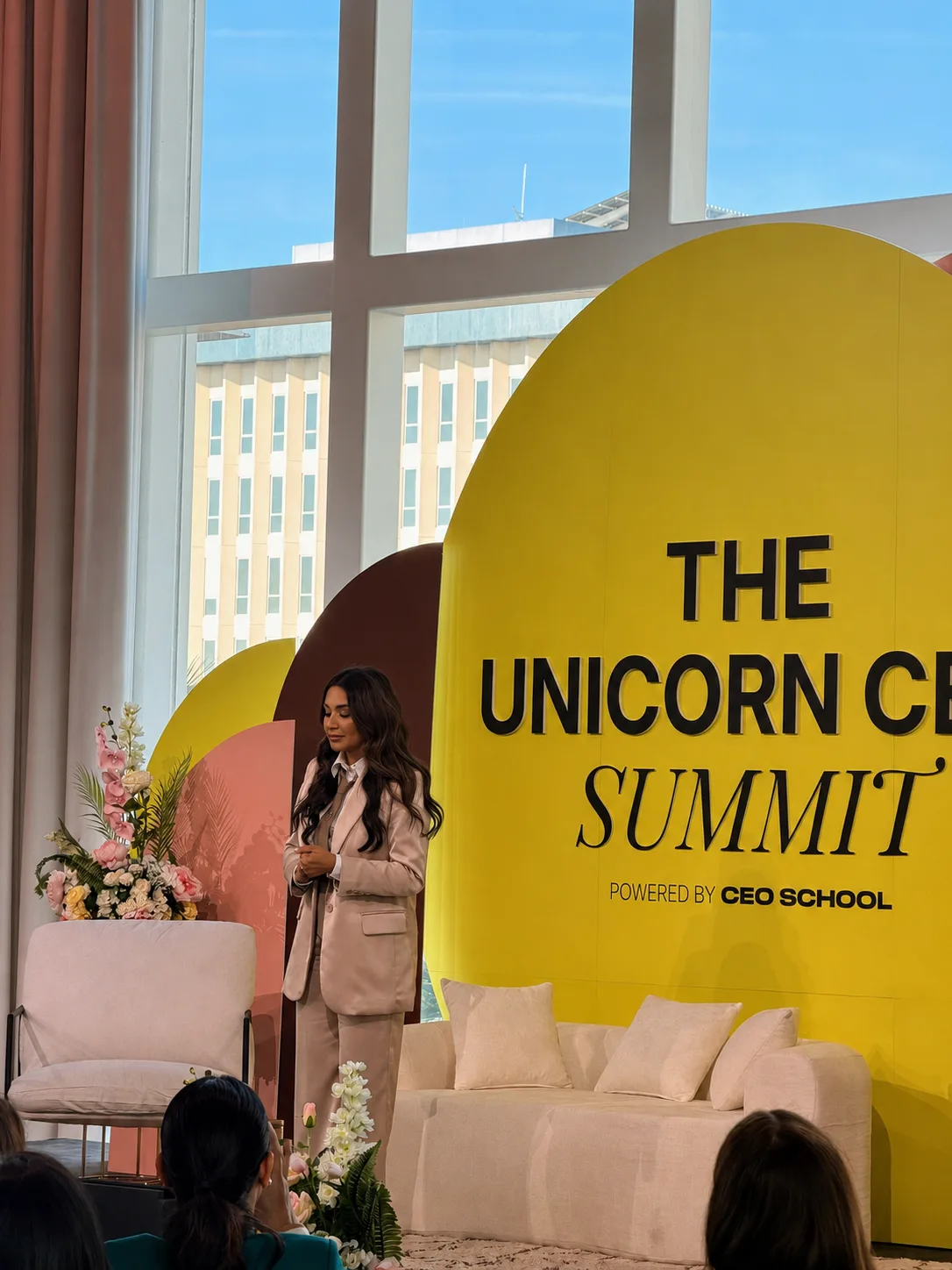 Speaker on a corporate summit stage with colorful custom arched backdrops