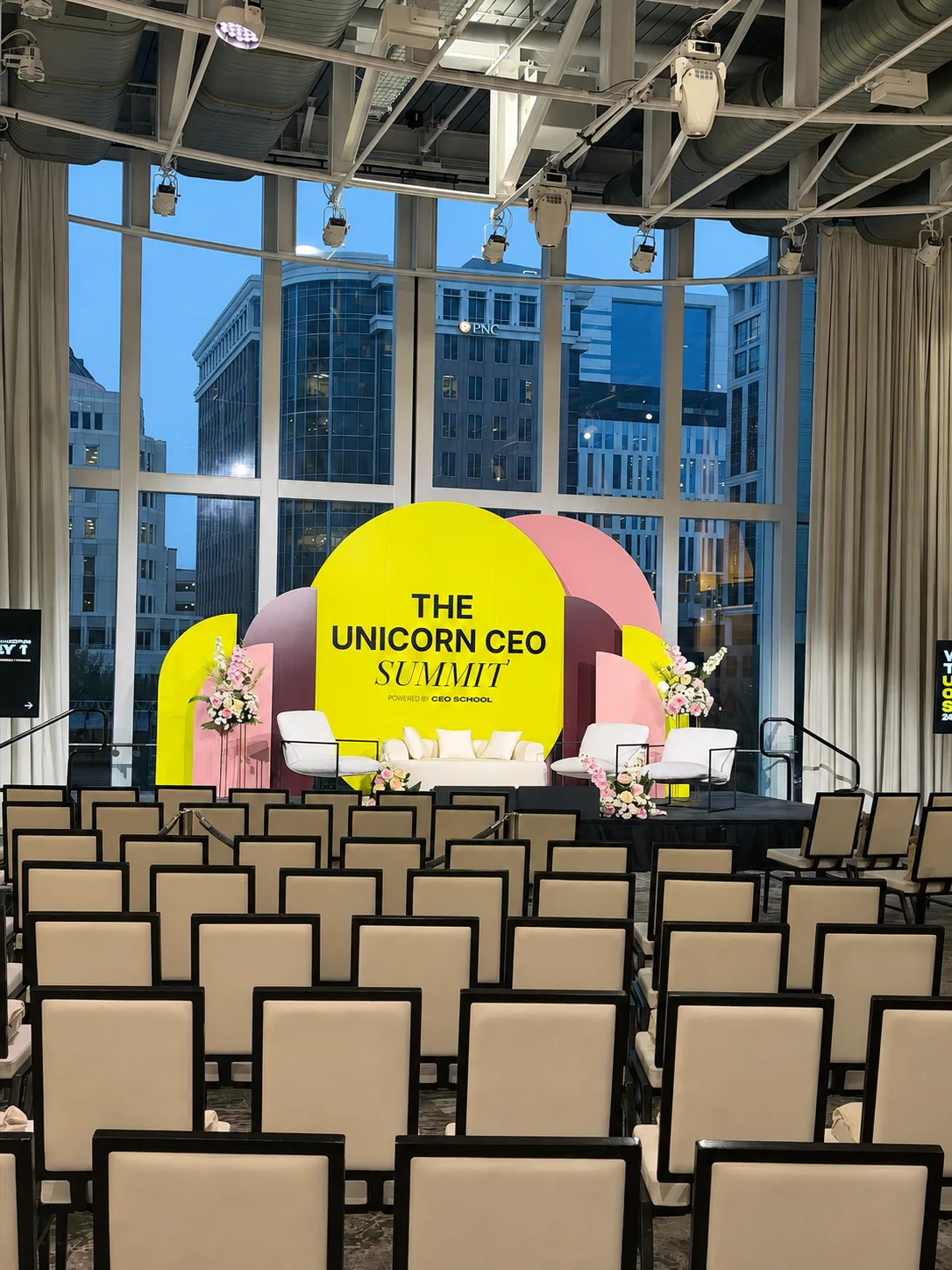 Conference seating styled with a branded arch and floral accents